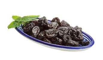 Dried plums in a bowl on white background photo