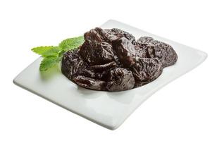 Dried plums in a bowl on white background photo