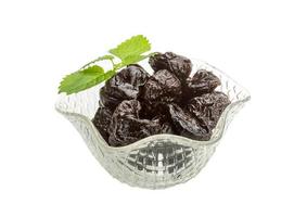 Dried plums in a bowl on white background photo