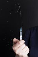 a small syringe in the hand of a person photo