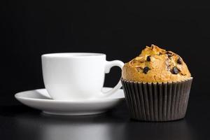 un delicioso bollo fresco y una taza de café aromático negro foto