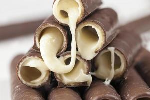 milk filling flows out of waffle tubes in chocolate photo