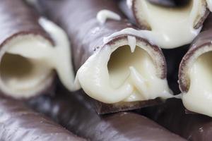 milk filling flows out of waffle tubes in chocolate photo