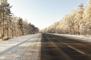 nevadas en la temporada de invierno y carretera asfaltada foto