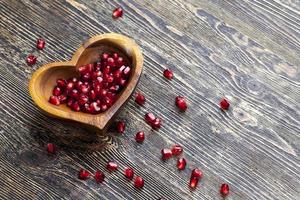 fresh pomegranate seeds in a heart shaped bowl photo