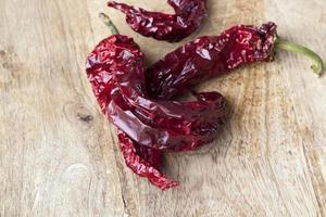 dried red hot pepper on a cutting board photo