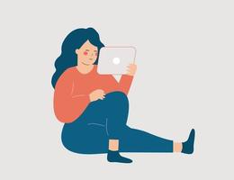 mujer joven sentada y pasando tiempo trabajando en línea en casa. la adolescente se comunica con amigos a través de las redes sociales y mira videos en su tableta. concepto independiente. material vectorial vector