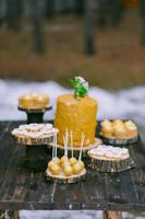 tortas en una mesa de madera para una barra de dulces de boda foto