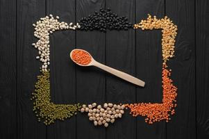 Legumes, overhead flat lay shot on a dark rustic wooden background with a place for text photo