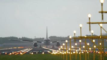 vliegtuig landing op verlichte baan in de vroege ochtend. video