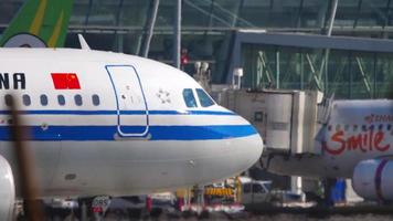 phuket, thailand 27 november 2019 - vliegtuigen van air china taxi's na de landing naar de terminal op de luchthaven van phuket video