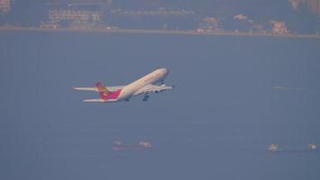 HONG KONG NOVEMBER 10, 2019 - Hong Kong Airlines Airbus A330 airliner climbing up in the air right after take off from Chek Lap Kok international airport, Hong Kong. video