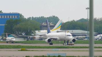 ALMATY, KAZAKHSTAN MAY 4, 2019 - Air Astana civil aircraft pulls a tractor at Almaty International airport video