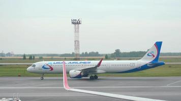 NOVOSIBIRSK, RUSSIAN FEDERATION JULY 24, 2021 Airbus of Ural Airlines taxis to the terminal after landing at Tolmachevo airport. Tourism and travel concept, air flight. video
