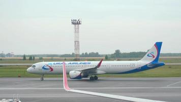 novosibirsk, russische federatie 24 juli 2021 airbus van ural airlines taxi's naar de terminal na de landing op de luchthaven van tolmachevo. toerisme en reisconcept, luchtvlucht. video