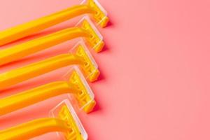 Disposable shaver on a light pink background with a copy space. photo