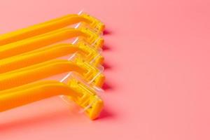 Disposable shaver on a light pink background with a copy space. photo