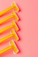 Disposable shaver on a light pink background with a copy space. photo