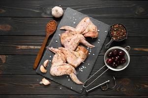 Marinated chicken wings with sweet cherry on a rustic wooden background photo