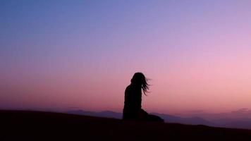 vrouw silhouet genieten van zandduinen in de woestijn in zonsondergang blauwe uur alleen. reizen levensstijl en wellness-concept. filmische reislustachtergrond video