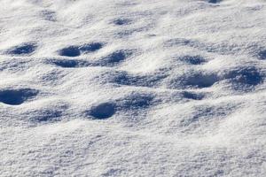 footprints and dents in the snow photo