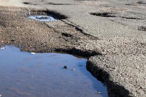 Drops of rain water on a fresh asphalt in the sun. photo