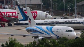 phuket, Tailandia 27 novembre 2019 - airasia, royal thai air force e bangkok air airbus a320 aerei di linea parcheggiati sul piazzale dell'aeroporto internazionale di phuket. vista dall'hotel vicino all'aeroporto video