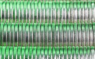 many round metal coins of silver color illuminated in green photo