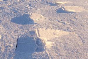 traces of shoes in the snow close up photo