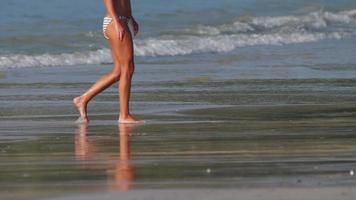 donna che cammina a piedi nudi sulla spiaggia di sabbia bagnata di nai yang, phuket video
