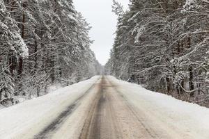nevadas en la temporada de invierno y carretera asfaltada foto