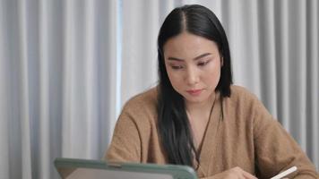 A female creator is taking notes in a notebook working on books and writing articles. video