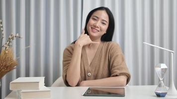 A happy girl makes a phone sign telling her to call back with a happy smile. Communicate with gestures, don't forget to call me. video