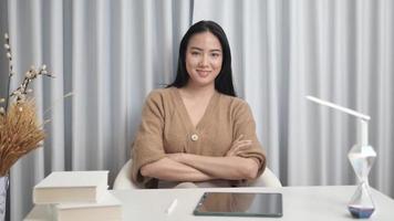 glückliche asiatische frau, die von zu hause aus arbeitet und laptop-computer benutzt und an ideen denkt. video