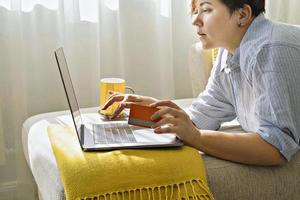 mujer con tarjeta de crédito usando una computadora portátil durante las compras en línea. concepto de viernes negro y lunes cibernético foto