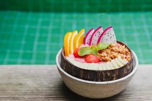 Fresh tropical organic smoothie bowl near swimming pool. photo