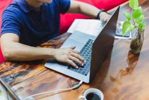 Businessman with paper bill on table working on laptop at home. photo