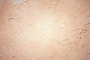 Light beige wall texture in daylight. Material for designers is beige. Natural vignette. photo