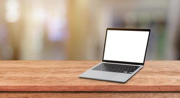 Modern Laptop computer with blank screen on wood table over blur bokeh light background. photo