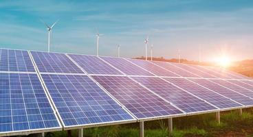 Solar panel with wind turbine against sunset sky background. Photovoltaic, alternative electricity source. sustainable resources concept. photo
