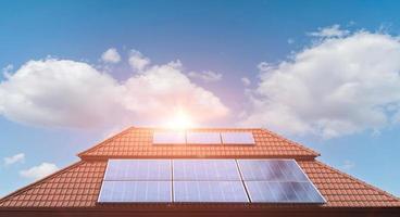 panel solar en el techo de una casa con fondo de nubes de cielo azul. foto