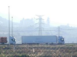 traffic on the highway and high voltage pylons in the background photo
