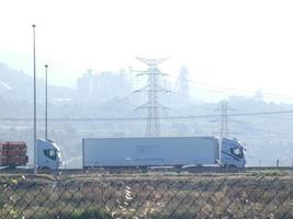 tráfico en la carretera y torres de alta tensión en el fondo foto