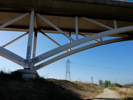 Silhouette of the arch of a modern bridge over a road photo