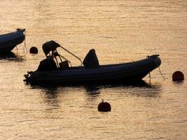 Backlighting of sport boats at anchor in a bay photo