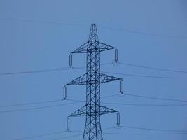 Silhouettes of high voltage metal towers in the mountains photo