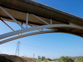 Silhouette of the arch of a modern bridge over a road photo