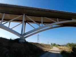 Silhouette of the arch of a modern bridge over a road photo