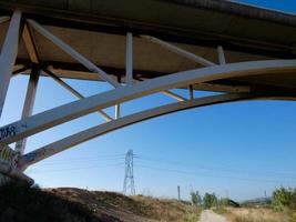 Silhouette of the arch of a modern bridge over a road photo