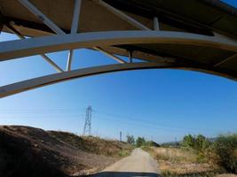 Silhouette of the arch of a modern bridge over a road photo